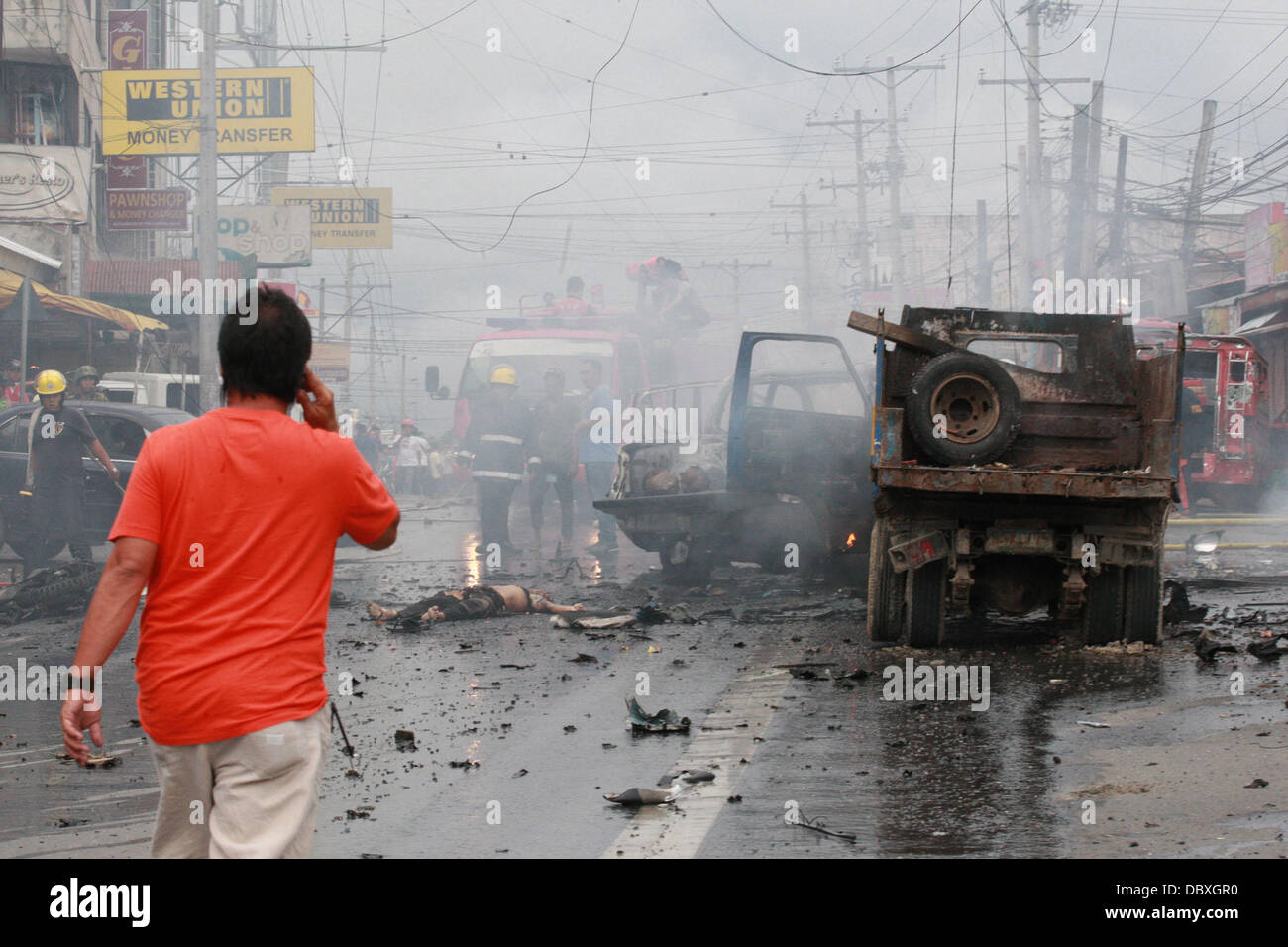 Cotabato, Philippinen. 5. August 2013. Szene nach einem tödlichen Autobombe Explosion in der viel befahrenen Straße des südlichen philippinischen Stadt Cotabato. Die tödlichere Explosion mindestens sechs Menschen getötet und verwundet 29. Es zur Detonation gebracht, wie ein Auto übergeben, trägt einen lokalen Beamter, entkam unverletzt. Es war nicht klar, ob sie das Ziel war. Cotabato befindet sich auf der Insel Mindanao, die durch einen 40jährigen Konflikt zwischen Regierungstruppen und islamistischen Rebellen zerbrochen worden. Es ist der zweite tödliche Bombardierung auf Mindanao in 10 Tagen. Eine Explosion in der Stadt Cagayan de Oro am 26. Juli acht Menschen getötet. Stockfoto