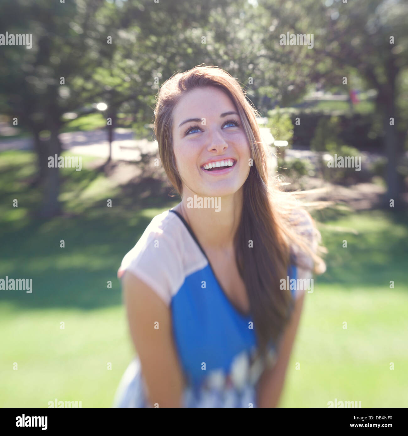 Lächelnde junge Frau zwar draußen in der Sonne an einem Sommertag. Stockfoto