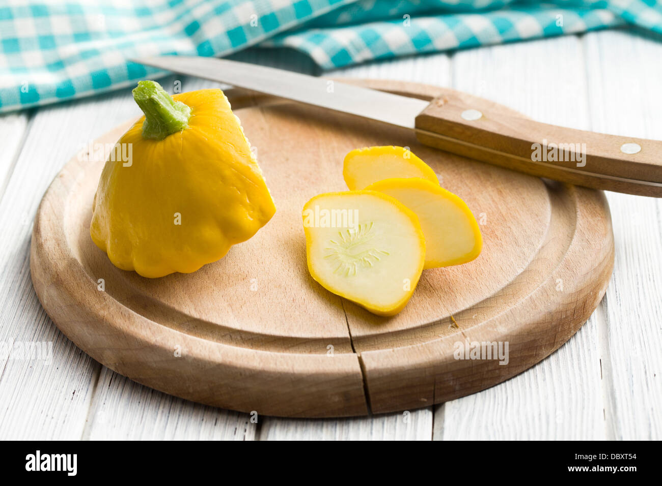 geschnittene gelbe Patisson am Küchentisch Stockfoto