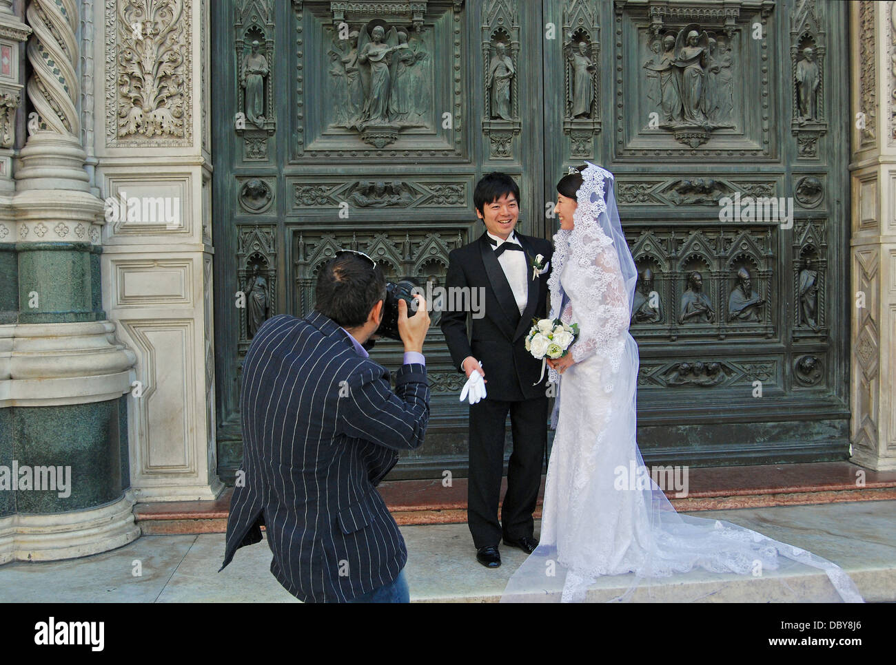 Asian paar haben Hochzeitsfotos an den Türen der Basilika di Santa Maria del Fiore in Florenz, Italien. Stockfoto