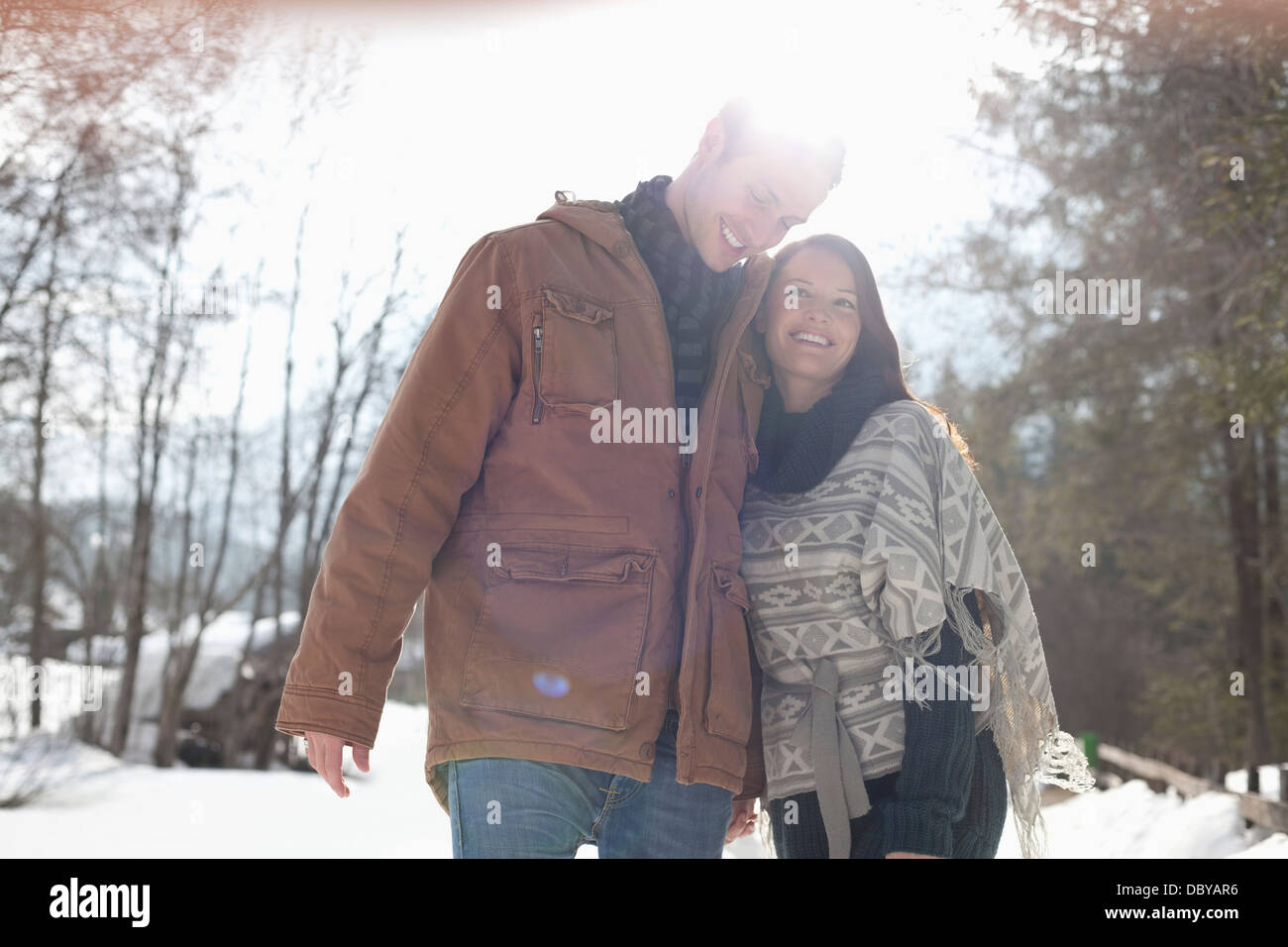 Glückliches Paar umarmt im verschneiten Wald Stockfoto