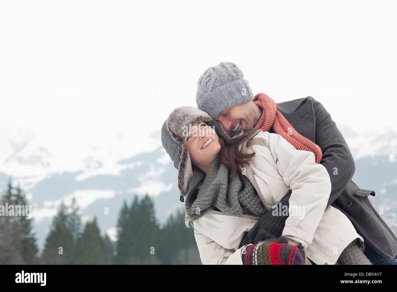 Glückliches Paar umarmt mit Bergen im Hintergrund Stockfoto
