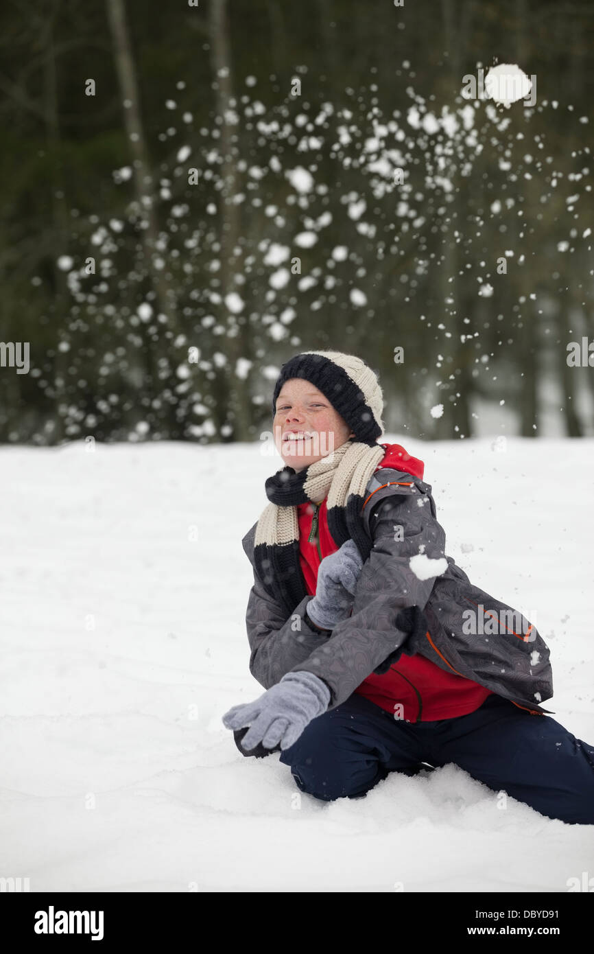 Porträt von fröhlicher Junge genießen Schneeballschlacht Stockfoto