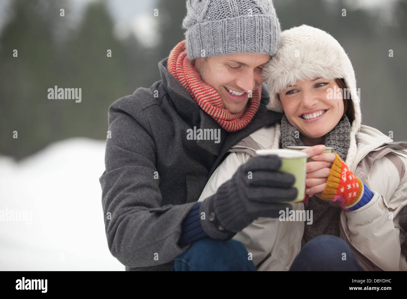 Glückliches Paar Kaffeetrinken im Schnee Stockfoto