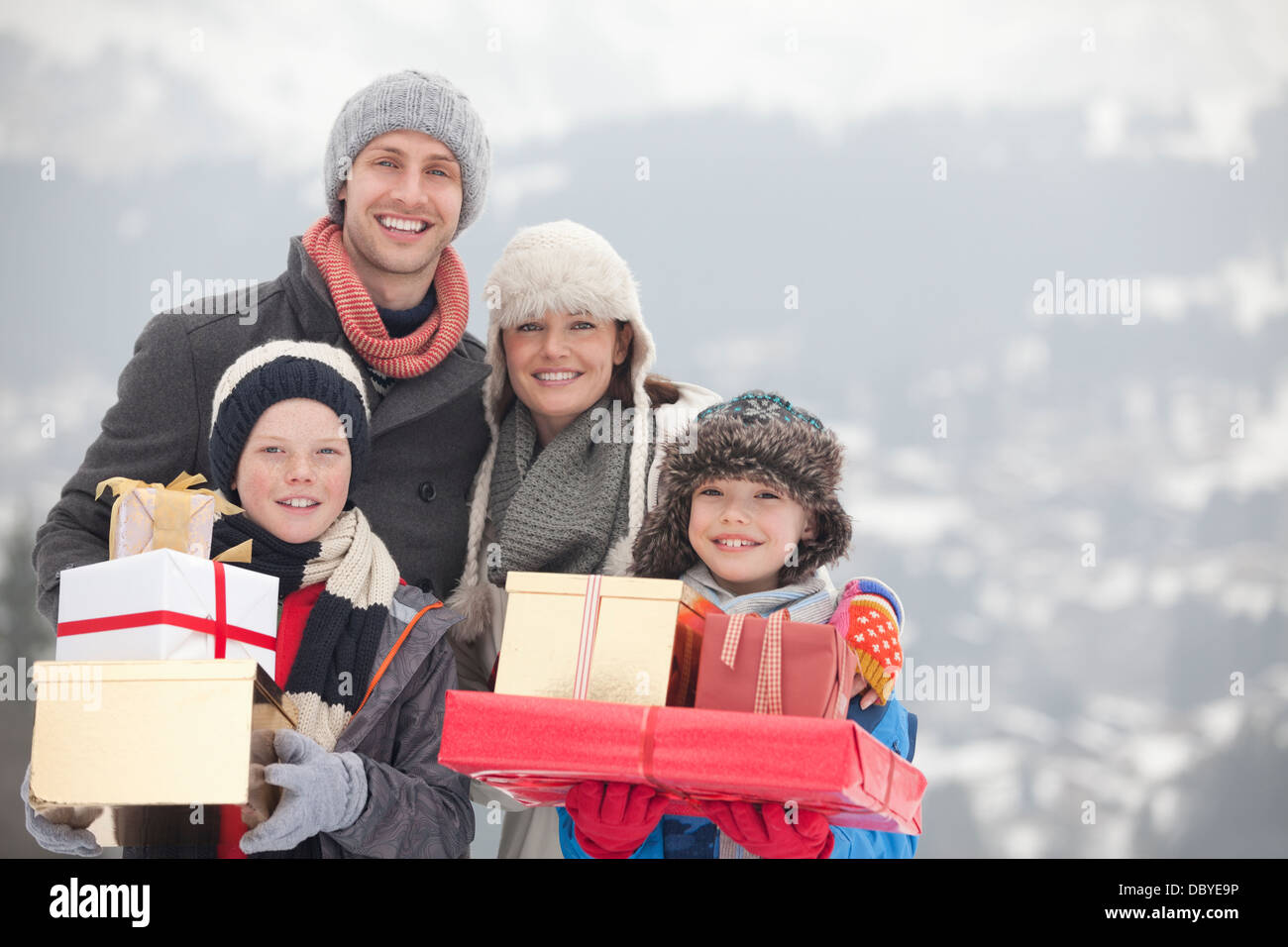 Porträt der glückliche Familie mit Weihnachtsgeschenke im Schnee Stockfoto