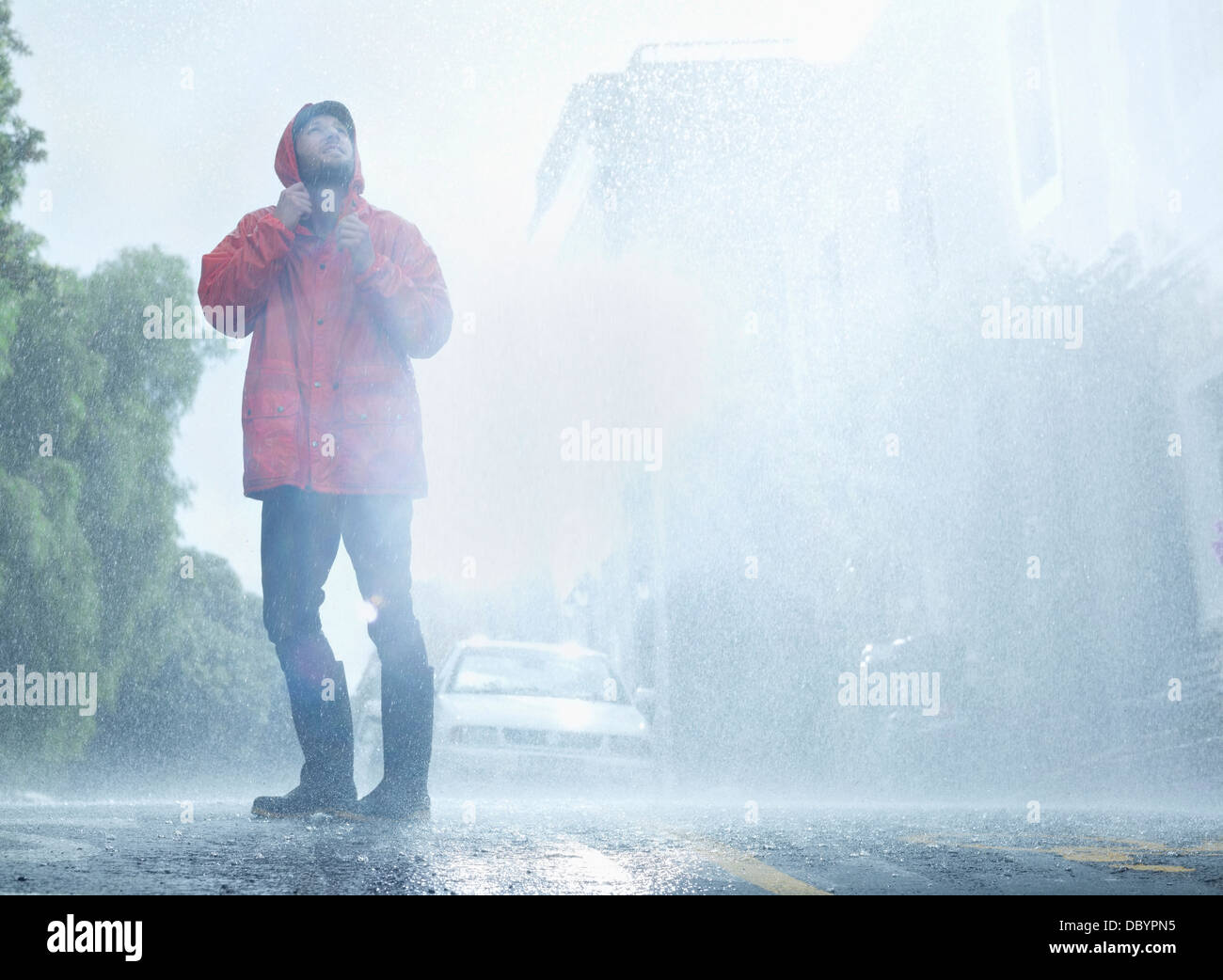 Mann mit Regenmantel im verregneten Straße Stockfoto