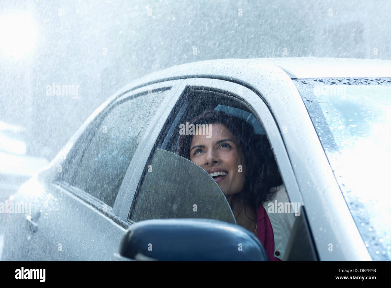 Geschäftsfrau im Auto Regen blickte lächelnd Stockfoto