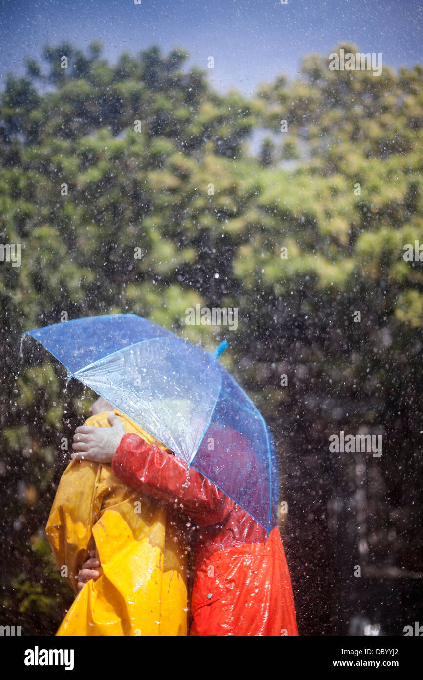 Paar umarmt unter Dach im Regen Stockfoto