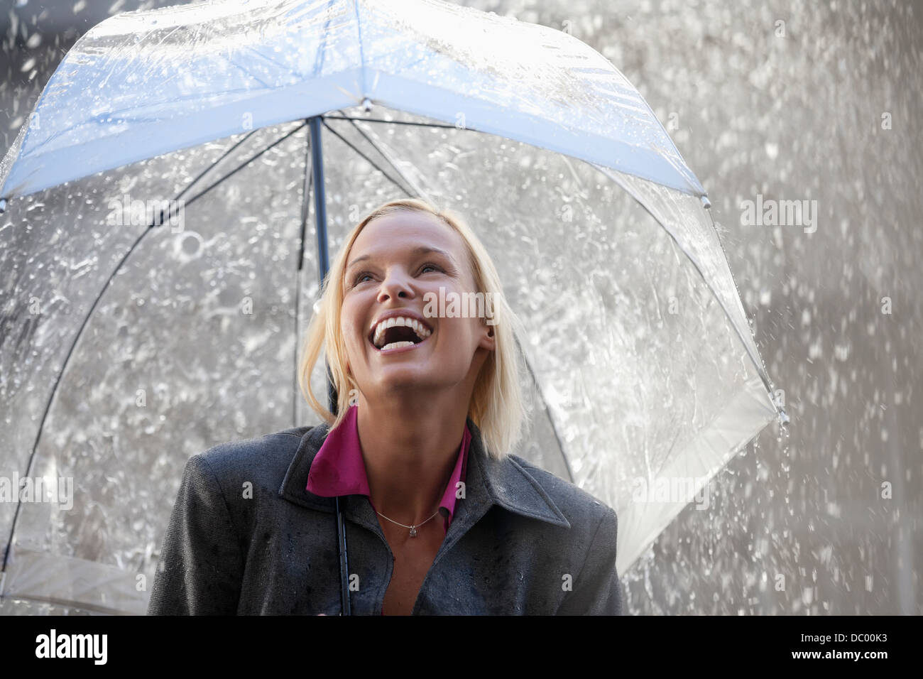 Lachend Geschäftsfrau unter Dach im Regen Stockfoto