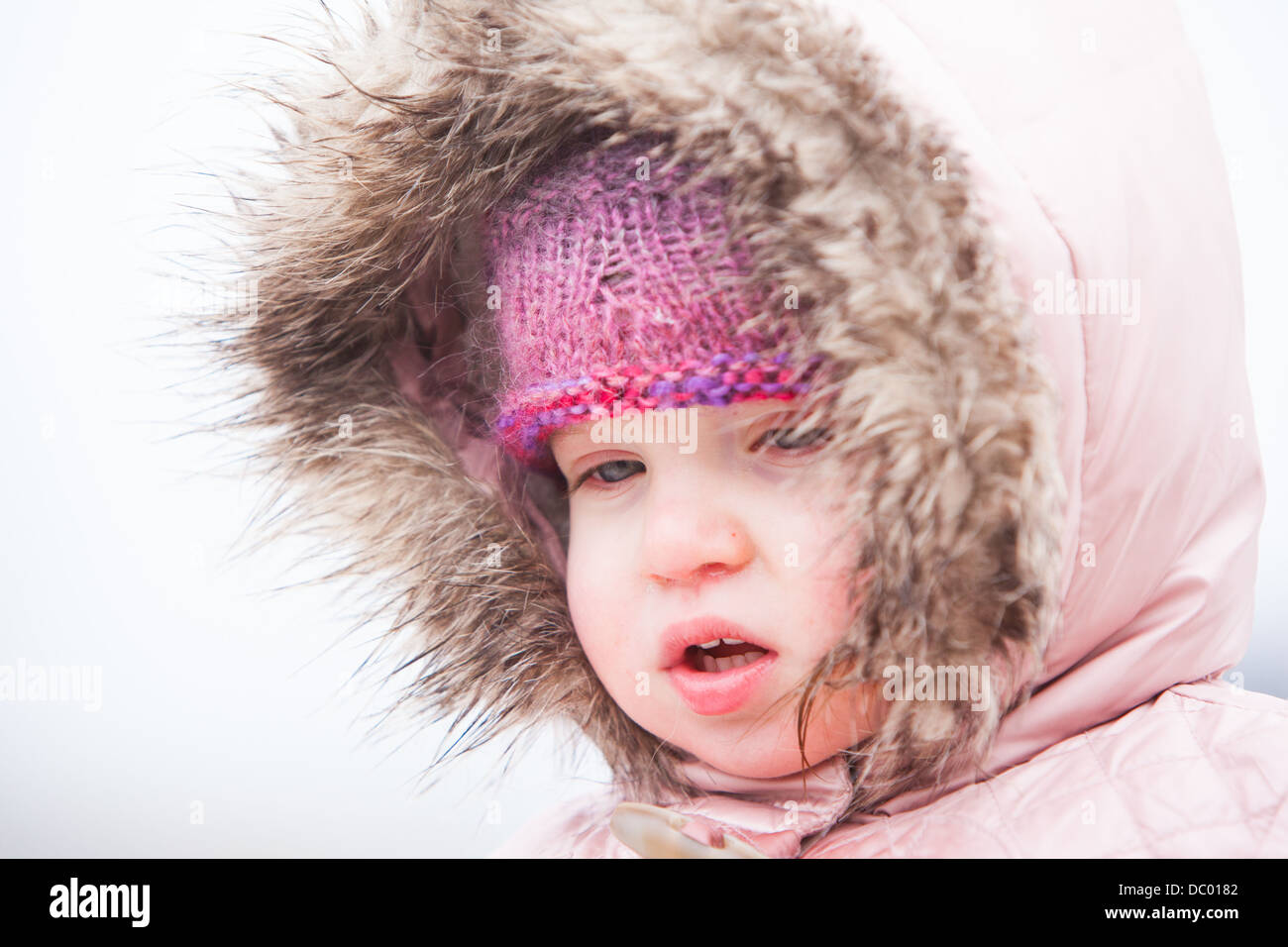 Ein Kleinkind steckt sich Warm in der kalten winterlichen Bedingungen auf See Gebirge in Victoria, Australien Stockfoto