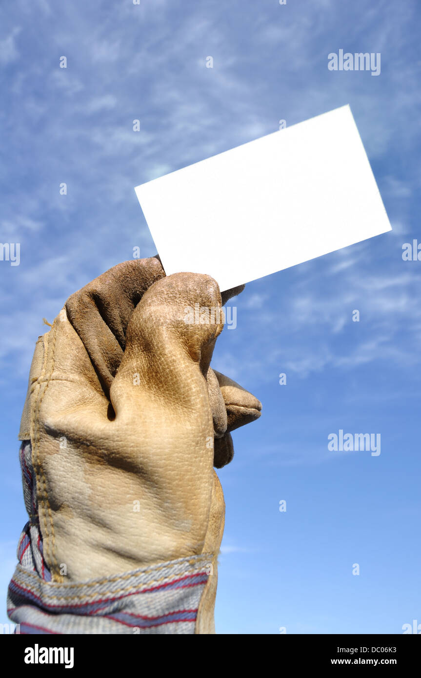 Arbeitnehmers behandschuhte Hand, die leer / Leere Visitenkarte Stockfoto