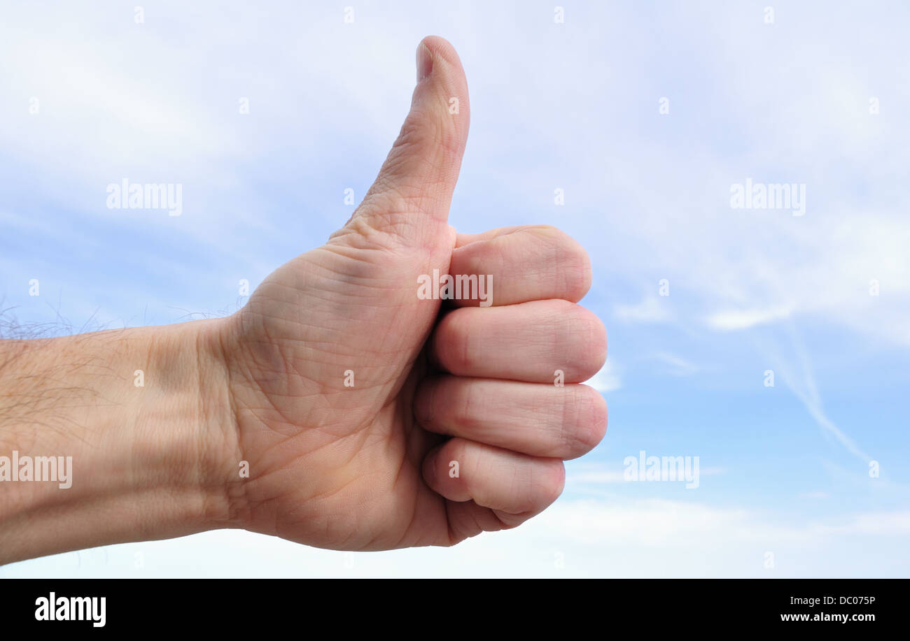 Männliche Hand macht draußen ein Schild mit Daumen hoch Stockfoto