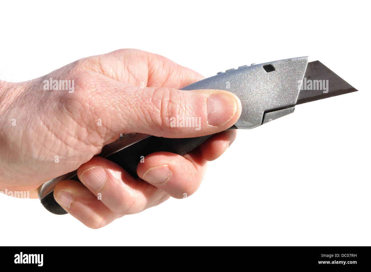 Männliche Hand, die ein Stanley-Messer / einen Boxschneider / ein Universalmesser hält Stockfoto