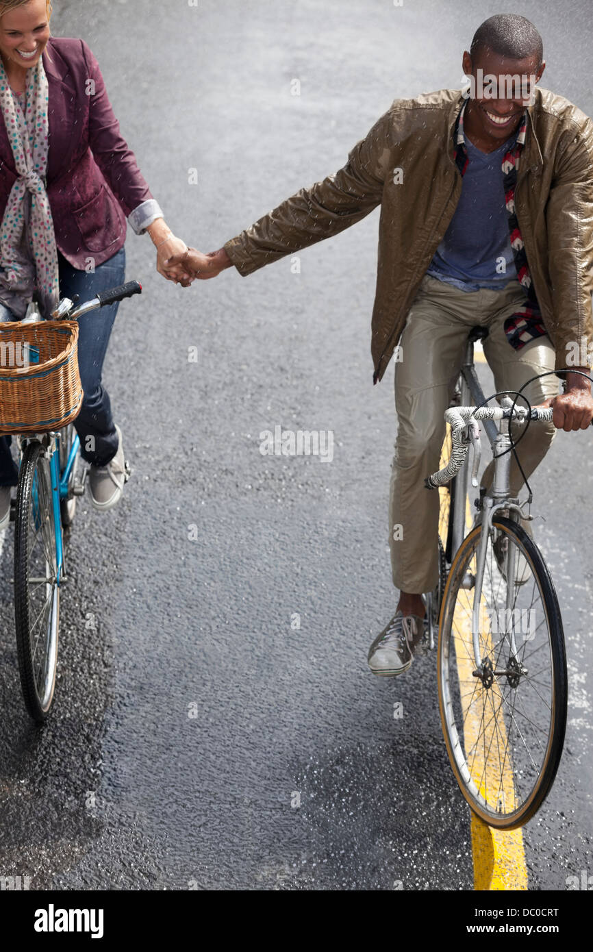 Glückliches Paar Hand in Hand und Fahrrad fahren Stockfoto