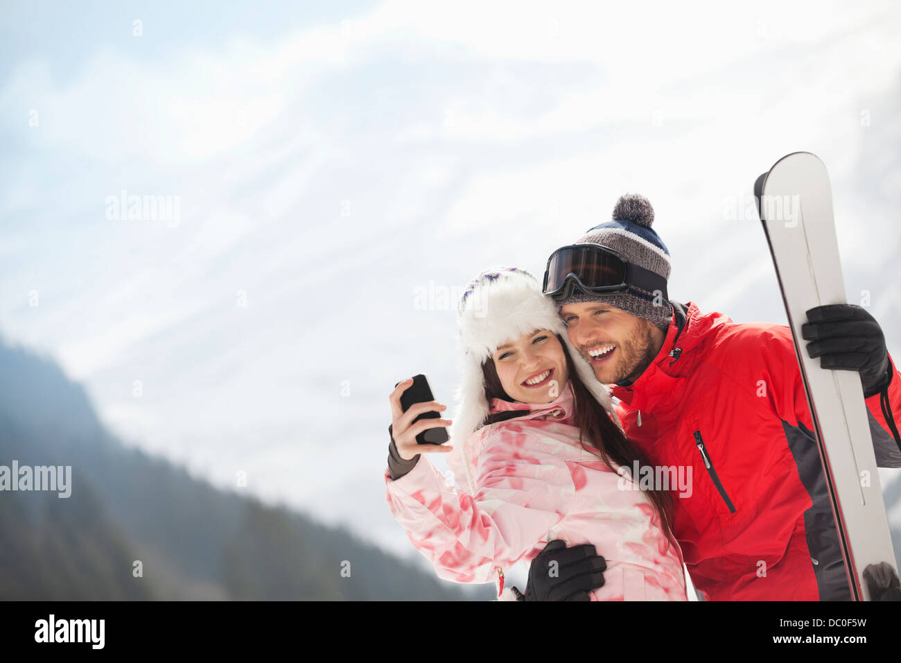 Brautpaar mit Skiern unter Selbstbildnis mit Kamera-Handy Stockfoto