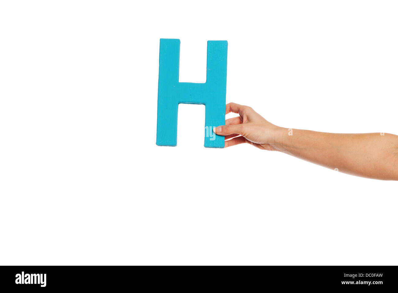 Hand hält den Buchstaben H von rechts Stockfoto