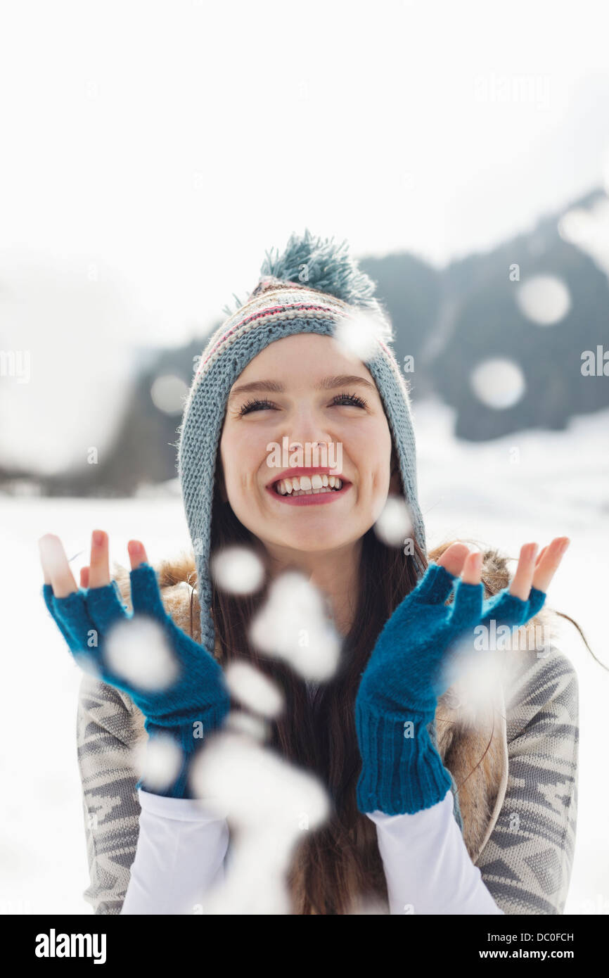 Glückliche Frau beobachten Schneefall Stockfoto