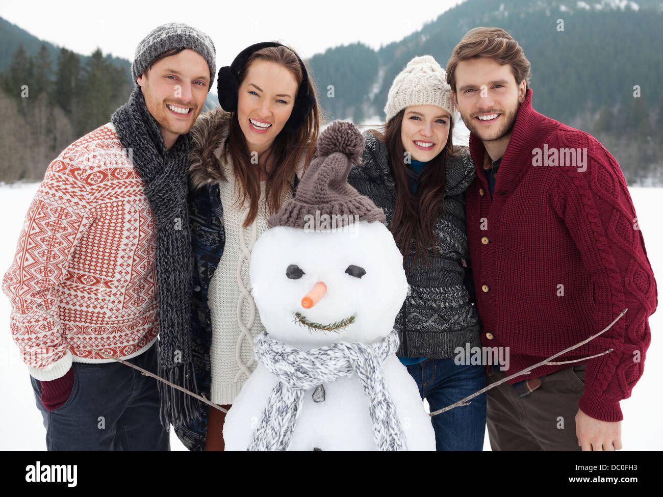 Porträt der happy Friends mit Schneemann Stockfoto