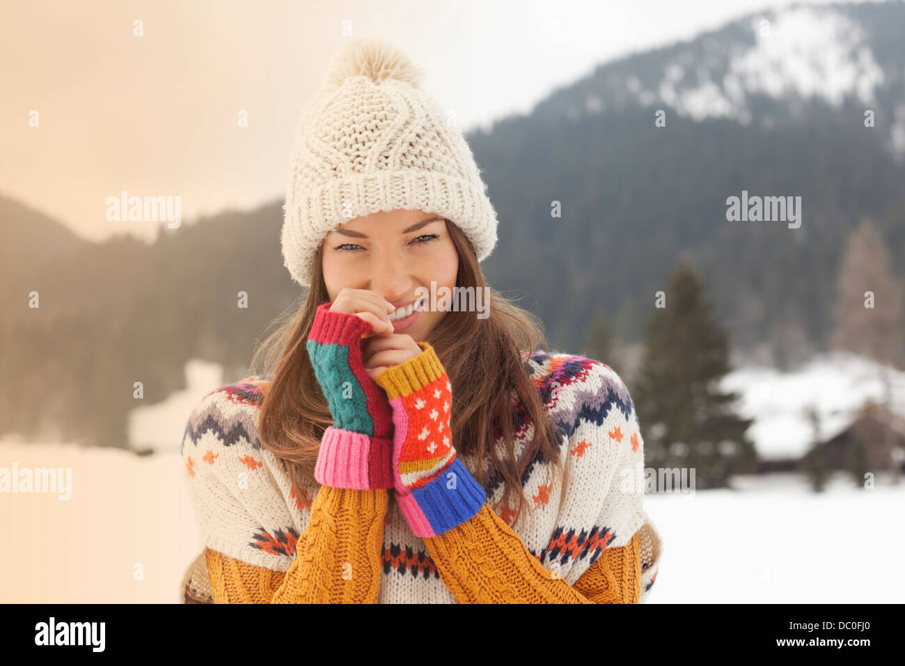 Porträt von lächelnden Frau mit Stricken Hut in schneebedecktes Feld Stockfoto