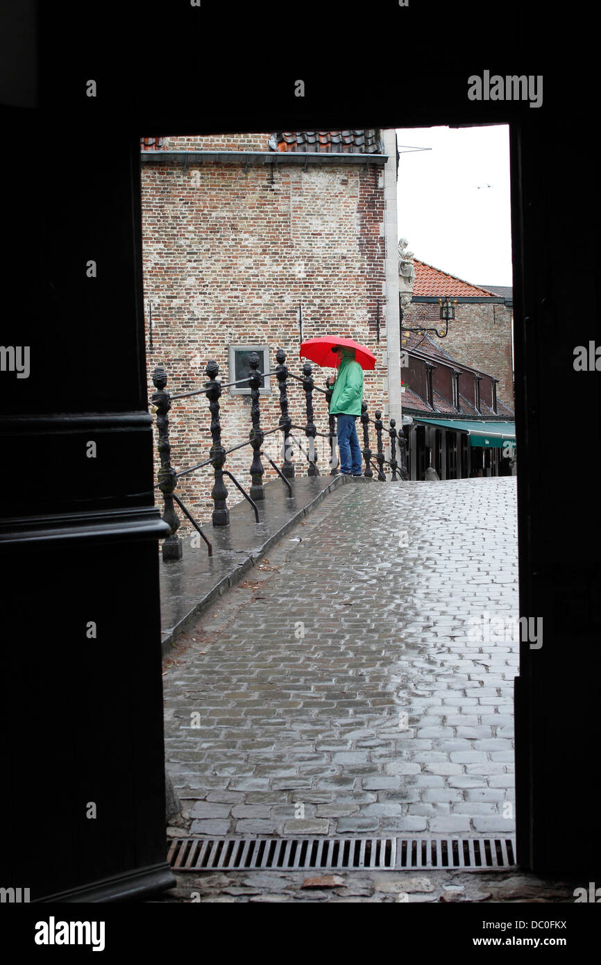 Brügge Belgien Flandern Europa Brugge Frau mit roten Regenschirm im Regen auf Brücke von Begijnhof Nonnenkloster Stockfoto