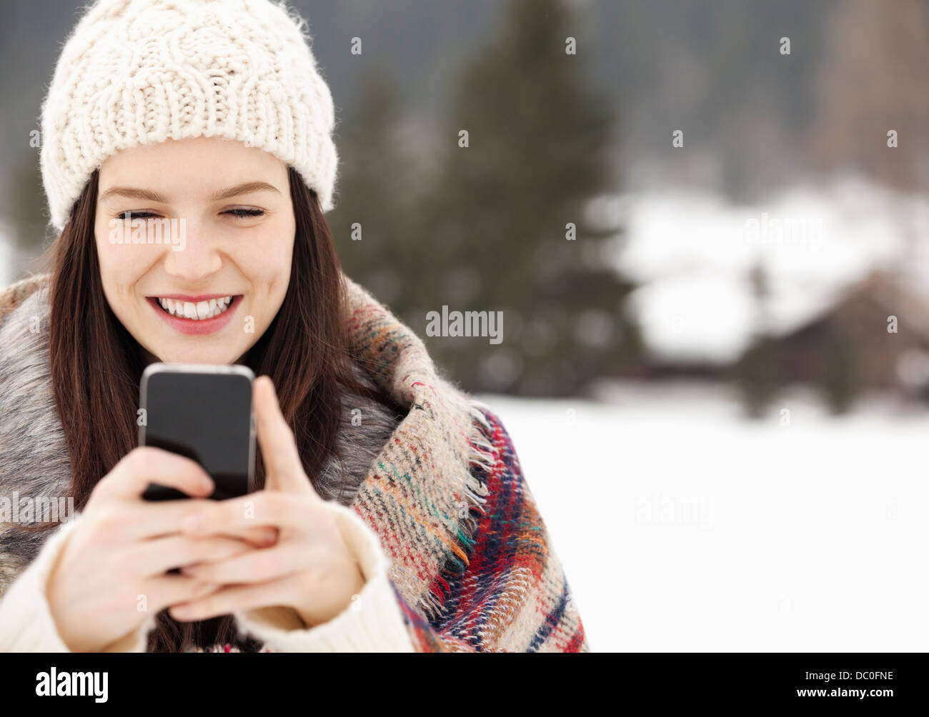 Nahaufnahme von Frau stricken Hut Text messaging mit Handy Stockfoto