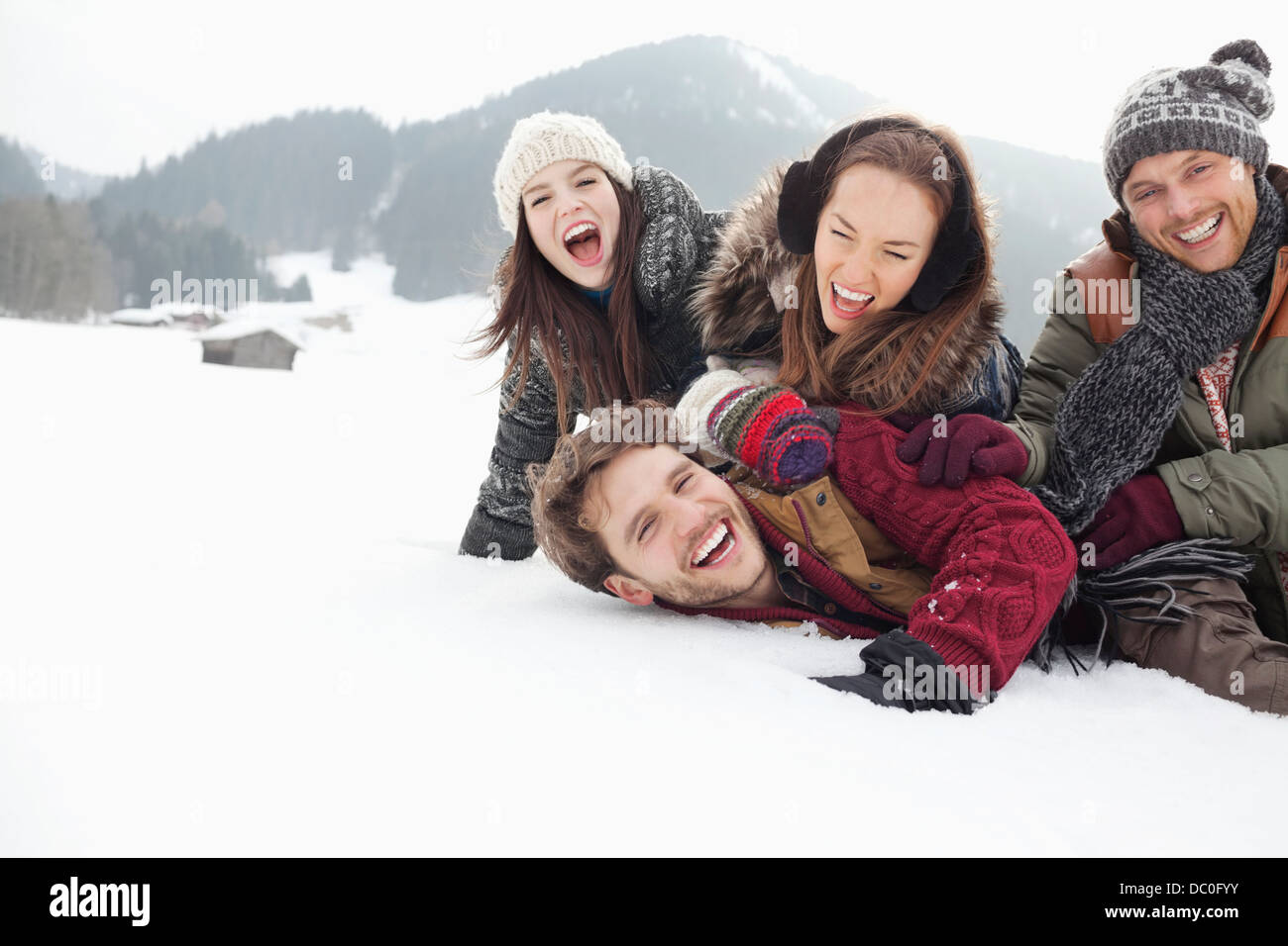 Verspielte Freunde Verlegung in schneebedecktes Feld Stockfoto