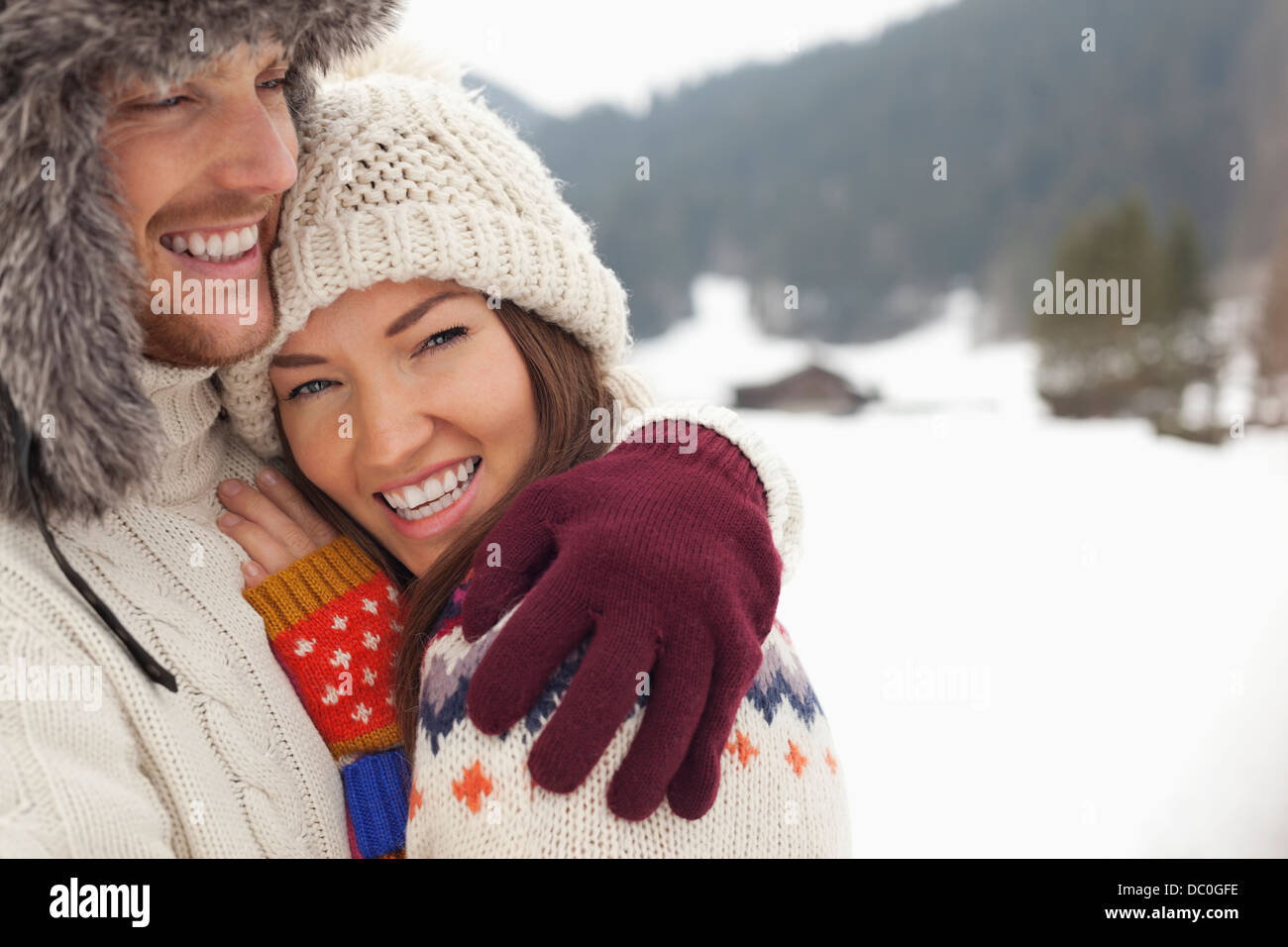 Porträt von glücklichen paar umarmt in schneebedeckten Feld hautnah Stockfoto