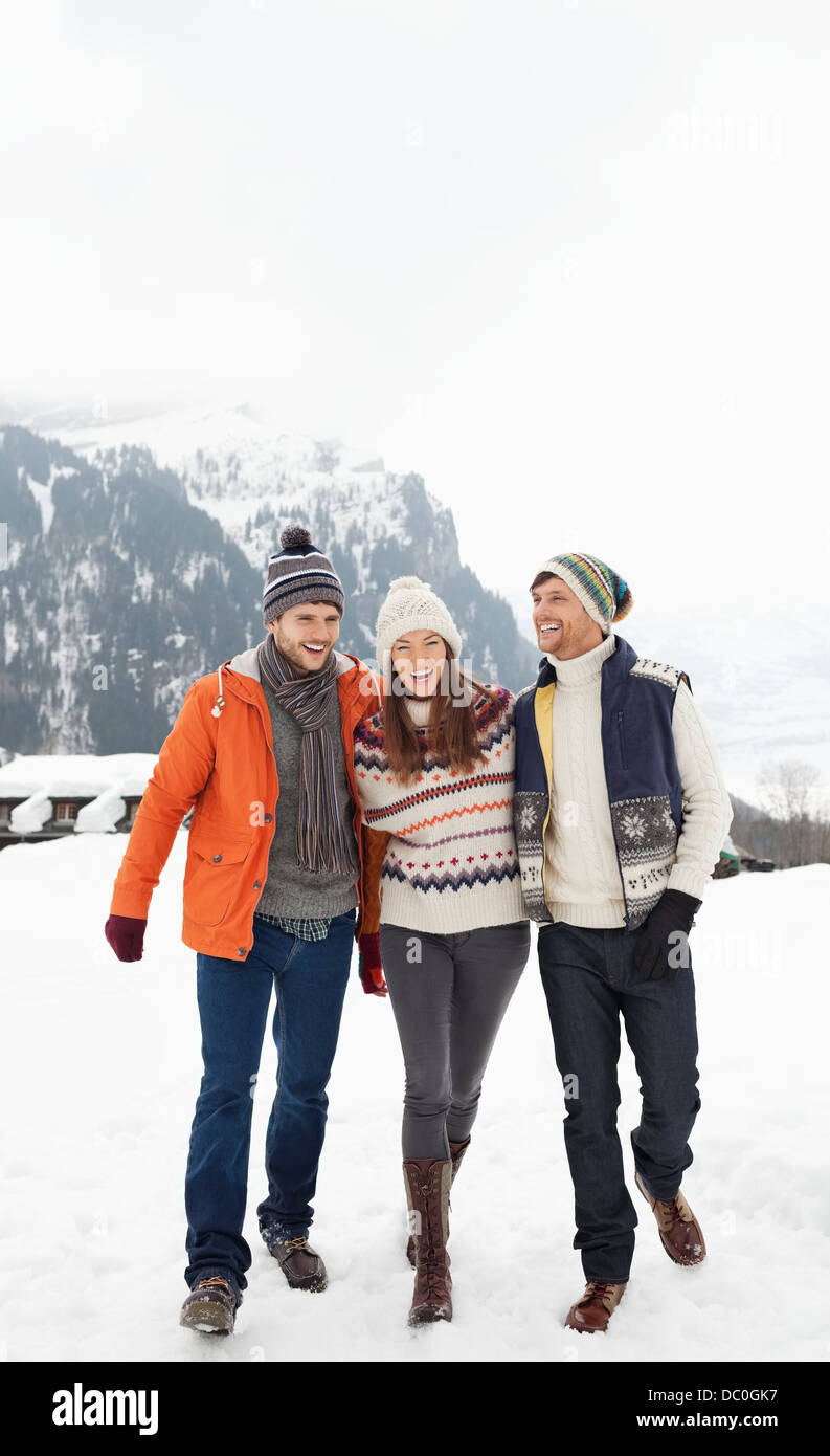 Glückliche Freunde Wandern in schneebedecktes Feld Stockfoto