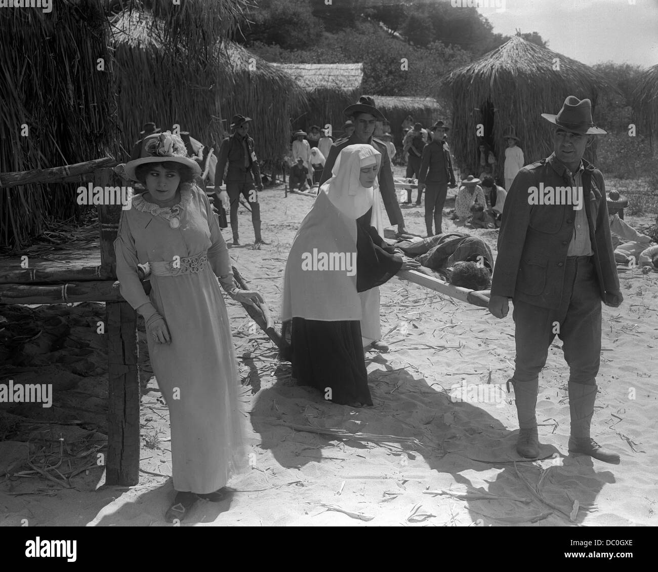 1910ER JAHRE FRAU TRETEN BEISEITE ALS SOLDATEN TRAGEN MANN AUF KEILRAHMEN Stockfoto