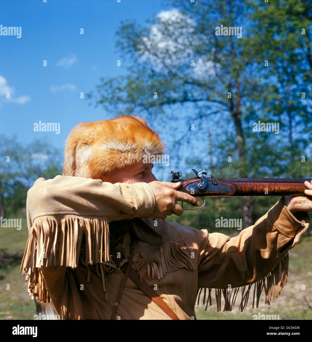 WILDNIS HUNTER FRONTIER RIFLEMAN FRANSEN JACKE FUCHS PELZ HUT MIT DEM ZIEL-GEWEHR Stockfoto