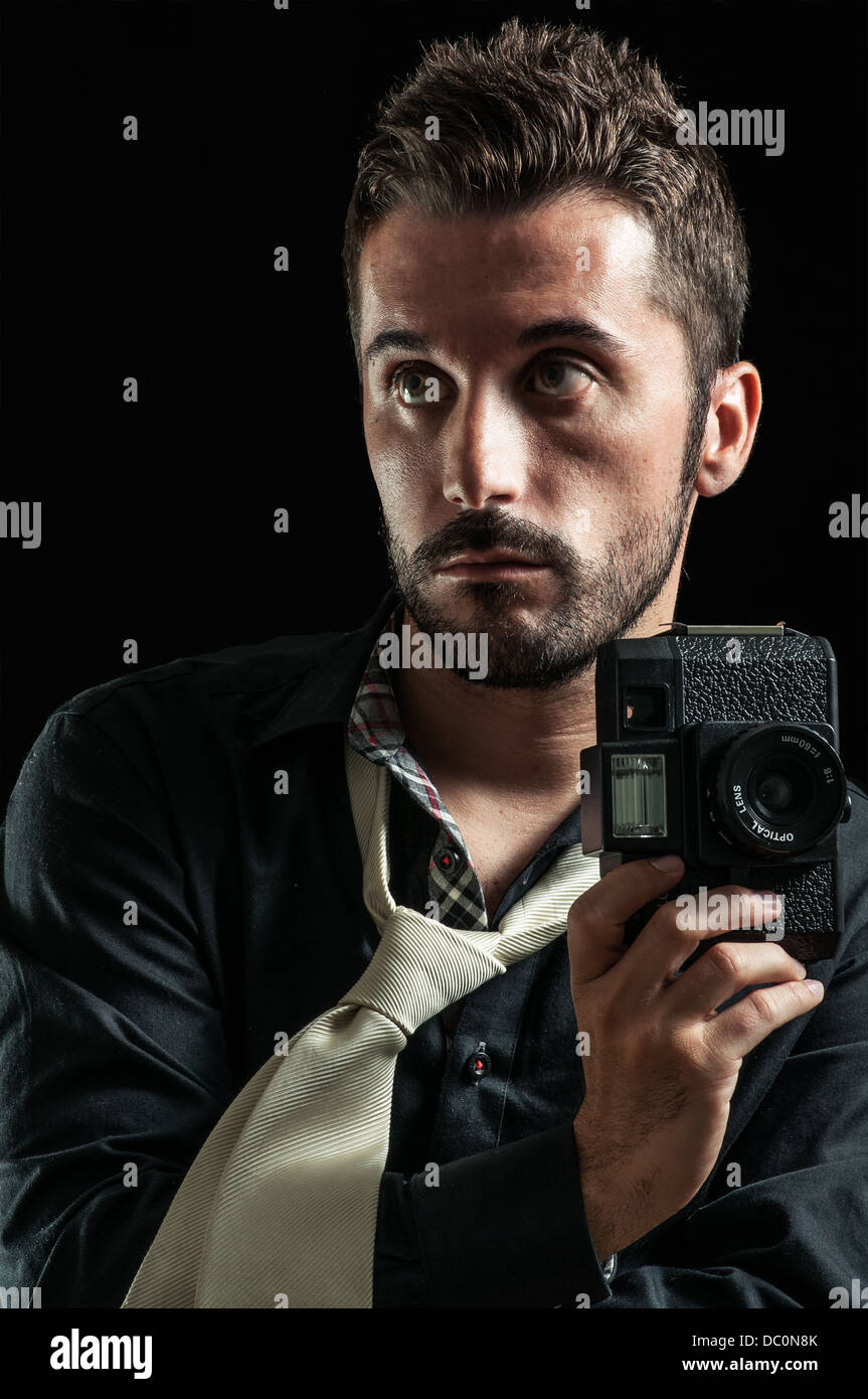 Eine junge Modell vorgibt mit seiner Kamera in einem Fotostudio Stockfoto