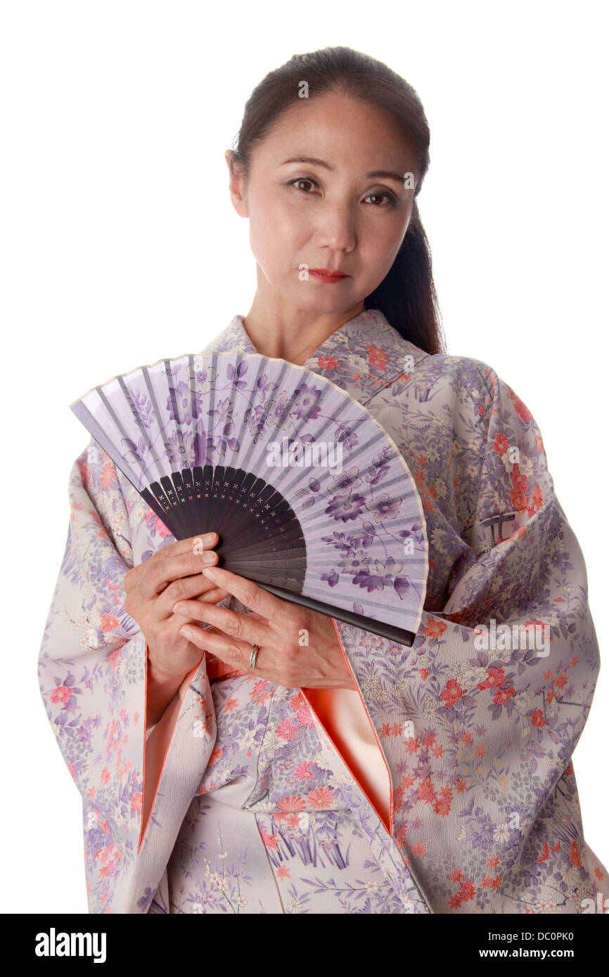 Japanische Dame trägt einen rosa und lila gemusterte Kimono und halten ein Fan Stockfoto