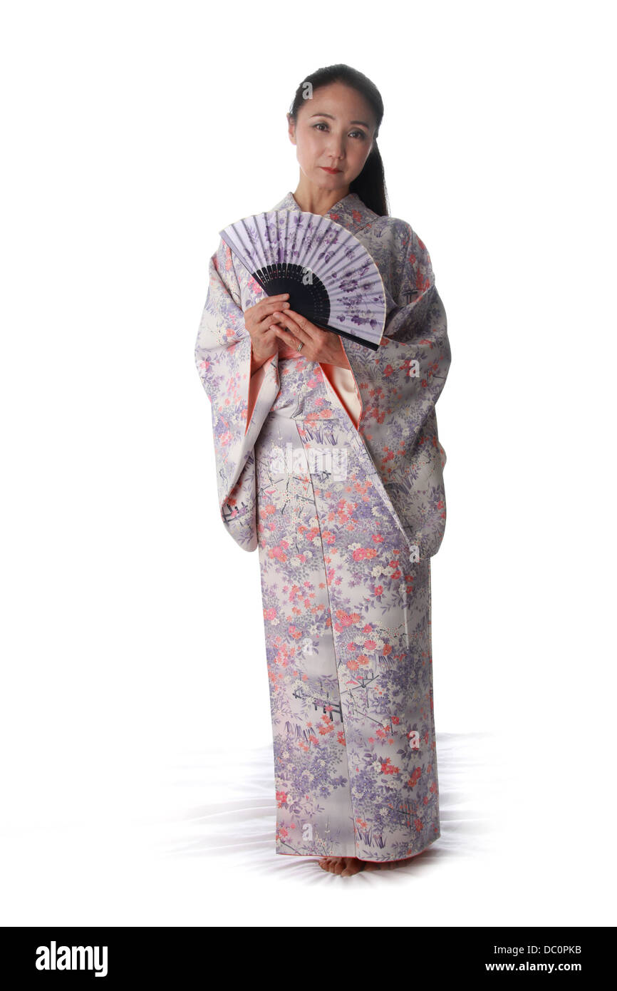 Japanische Dame trägt einen rosa und lila gemusterte Kimono und halten ein Fan Stockfoto