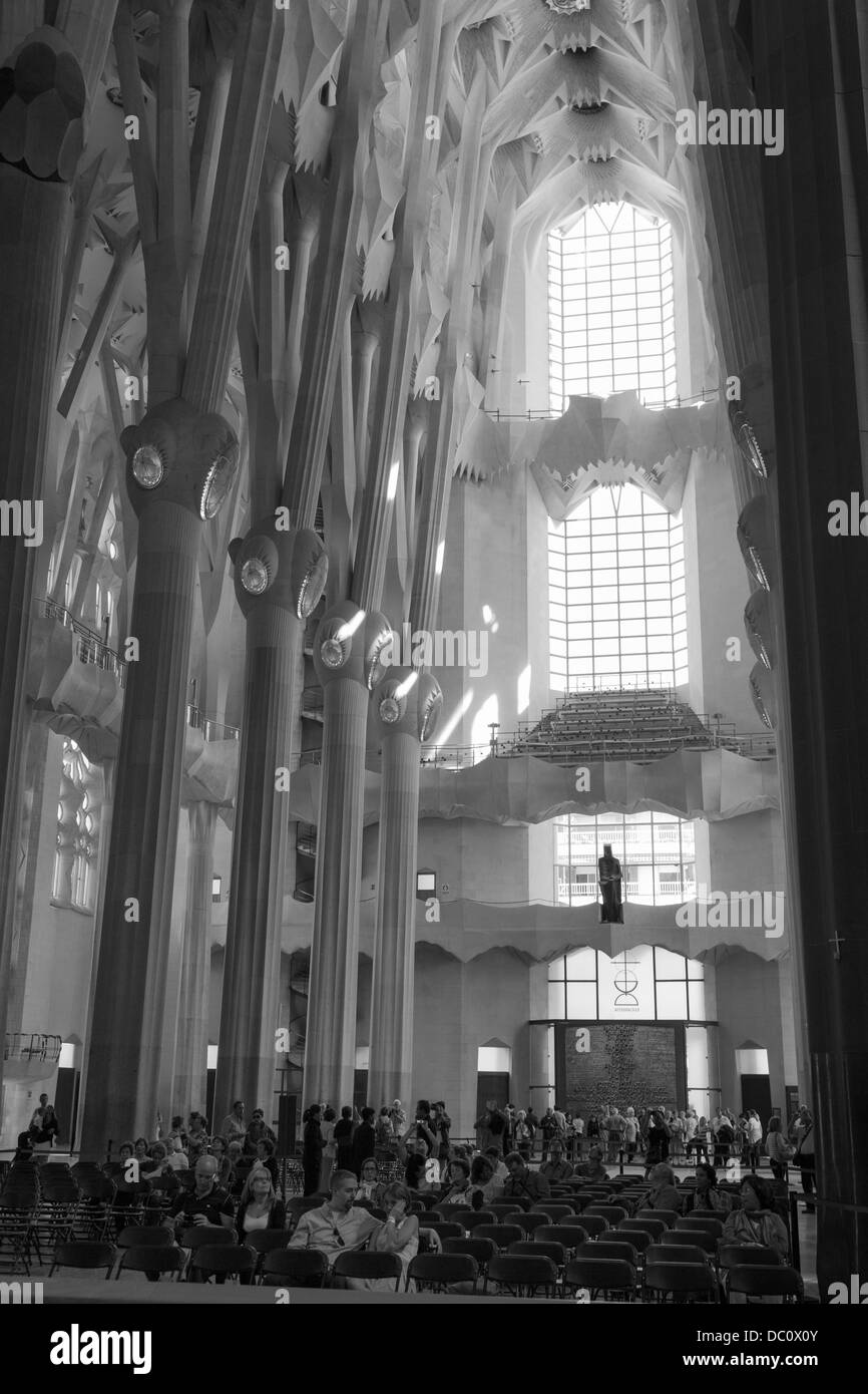 Besucher sitzen im Kirchenschiff der La Sagrada Familia Stockfoto