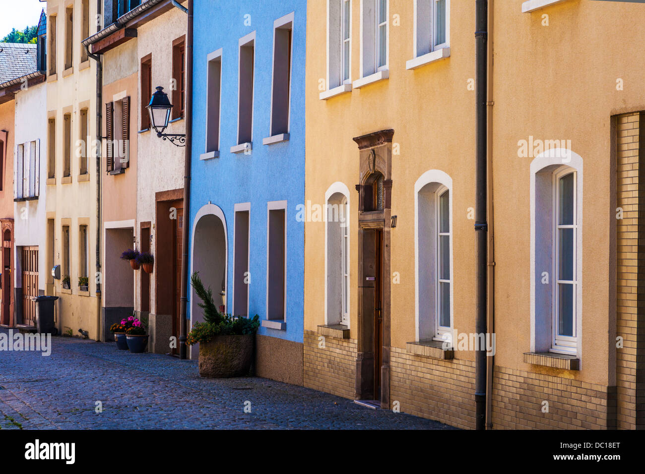 Bunte Häuser in einer schmalen gepflasterten Seitenstraße in dem malerischen Dorf von Vianden in Luxemburg. Stockfoto