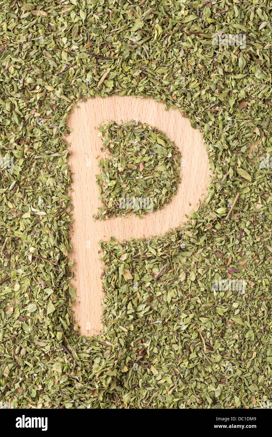 Buchstaben P geschrieben mit Oregano auf Holztisch Stockfoto