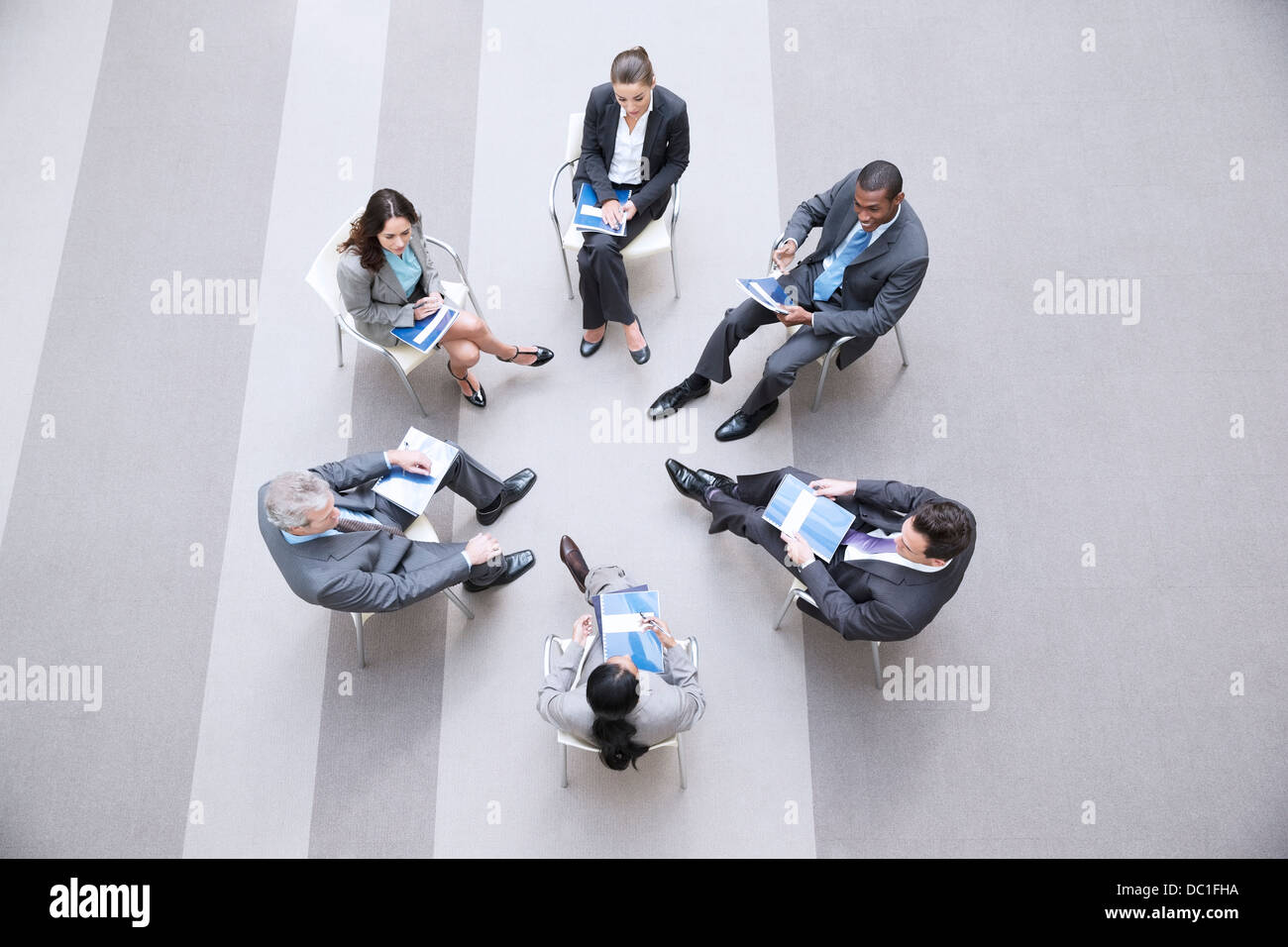 Erhöhte Ansicht von Geschäftsleuten, die im Kreis sitzen Stockfoto
