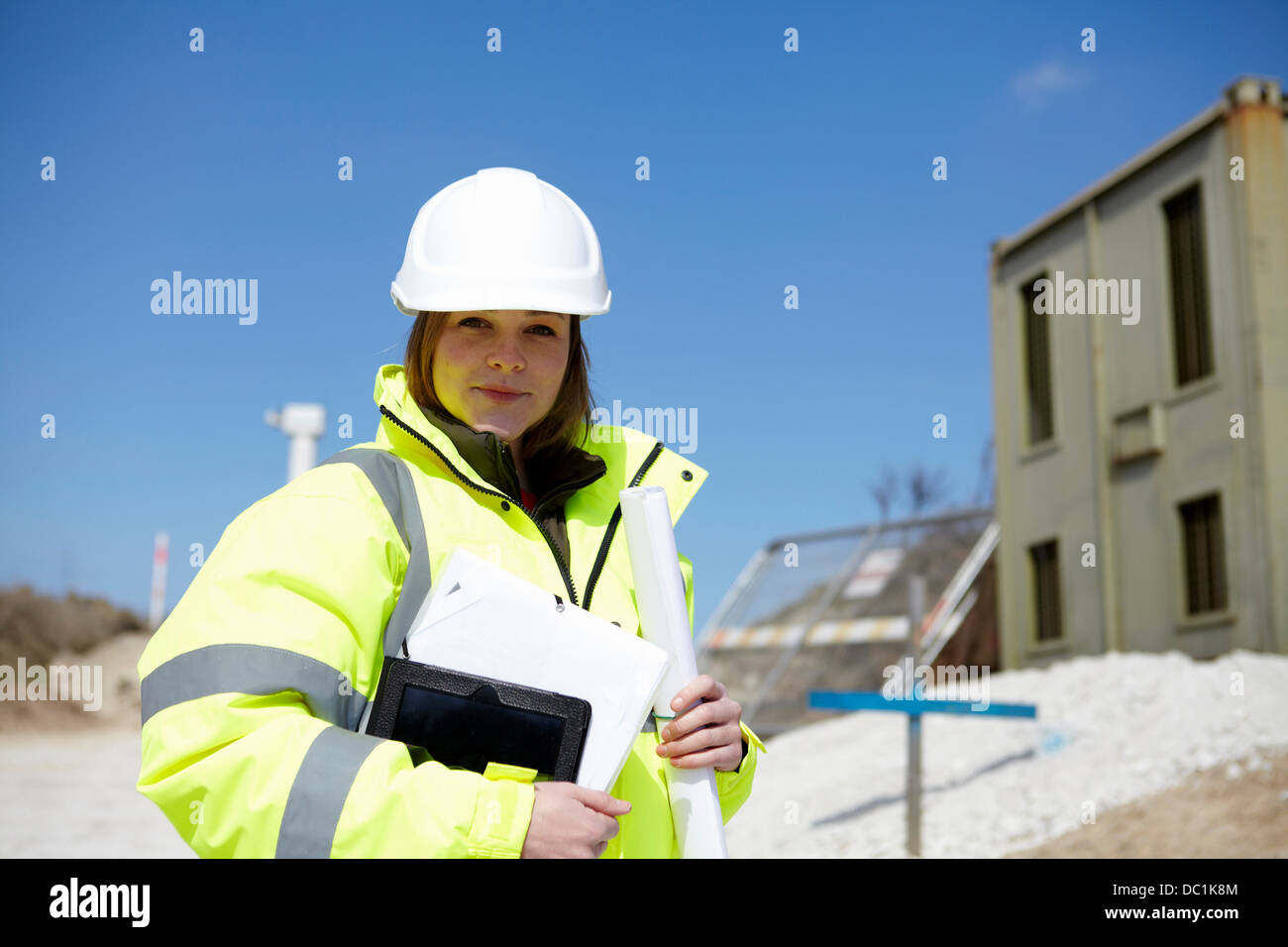 Porträt der Frau mit Blueprint und digital-Tablette auf Baustelle Stockfoto