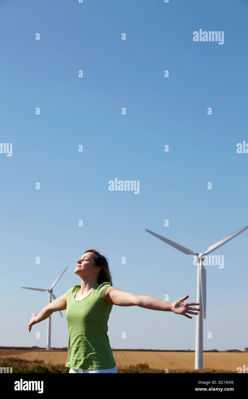 Junge Frau imitiert Windkraftanlagen Stockfoto