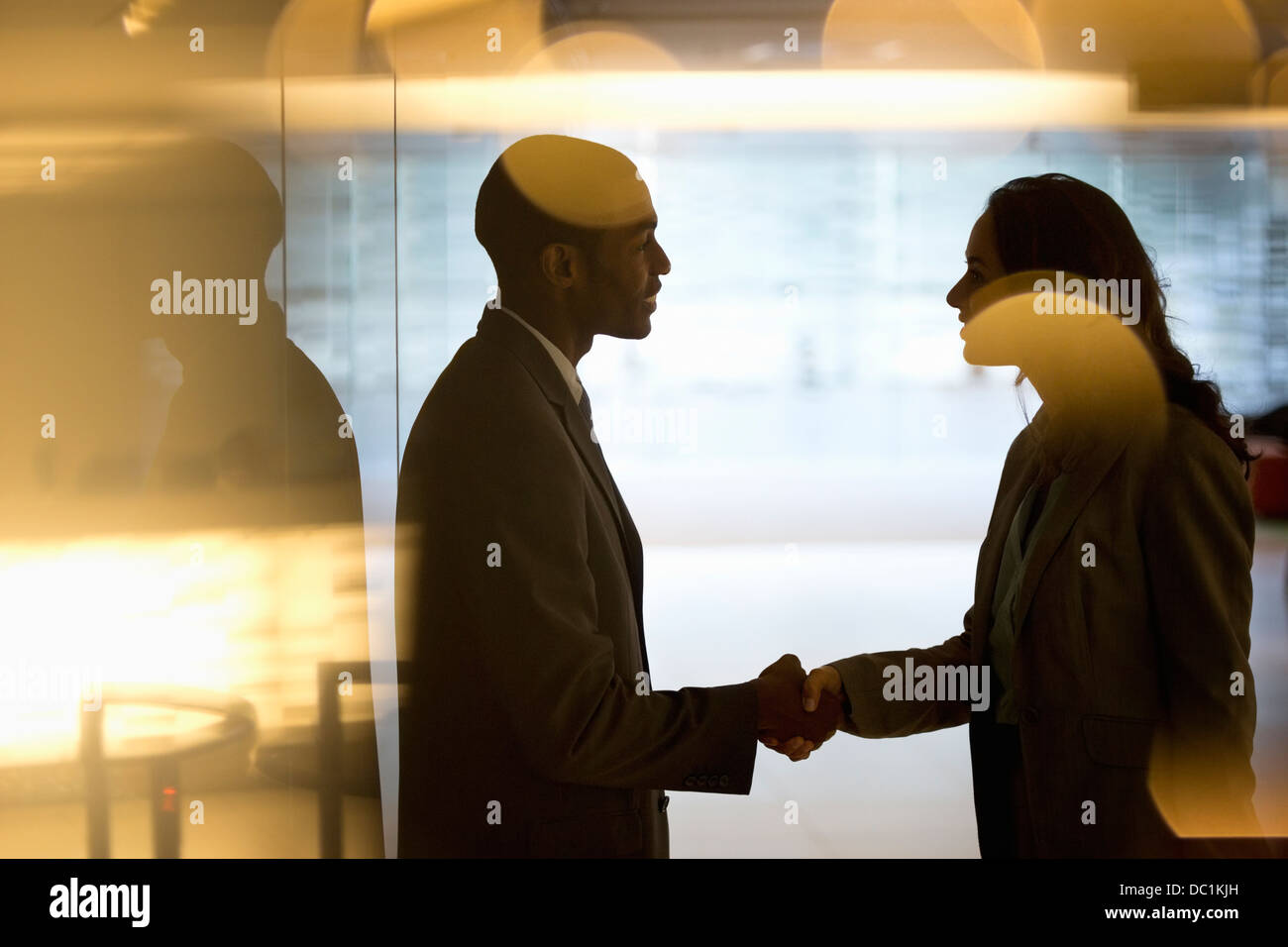 Unternehmer und Unternehmerin Handshaking in lobby Stockfoto