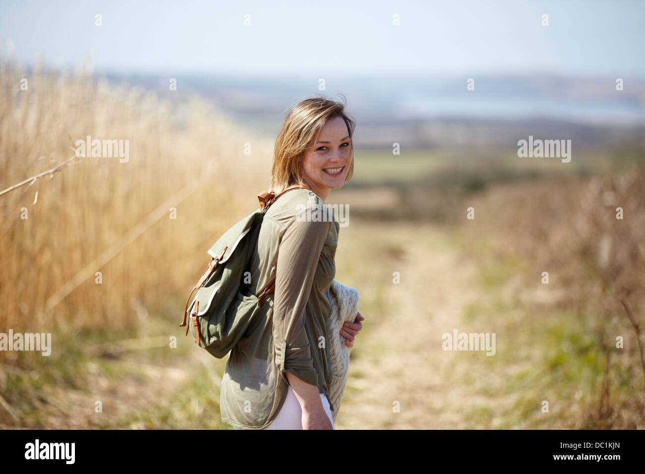 Porträt der jungen Frau auf Feldweg neben Feld aus Schilf Stockfoto
