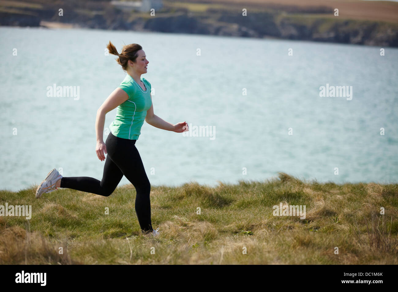 Junge Frau in der Nähe Küste läuft Stockfoto