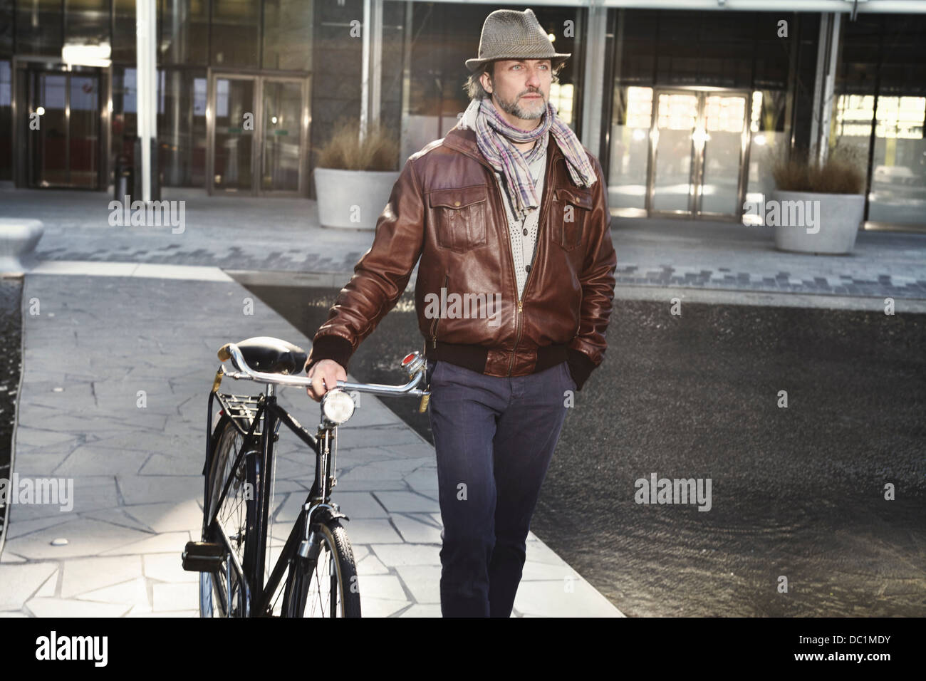Mitte erwachsenen Mann zu Fuß mit dem Fahrrad in die Stadt Stockfoto
