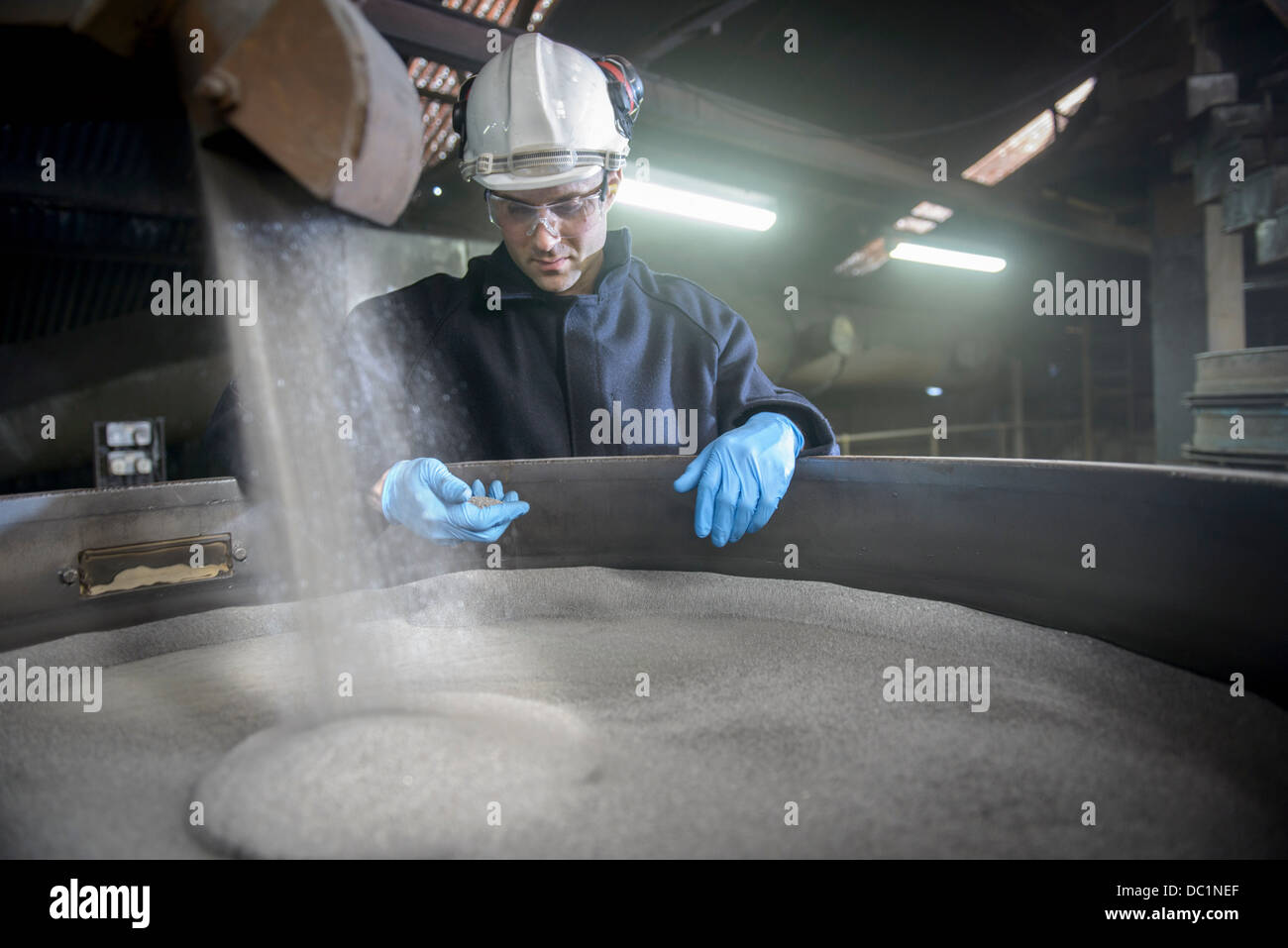 Arbeiter überprüfen Behälter mit Stahlschrot in Stahlgießerei Stockfoto