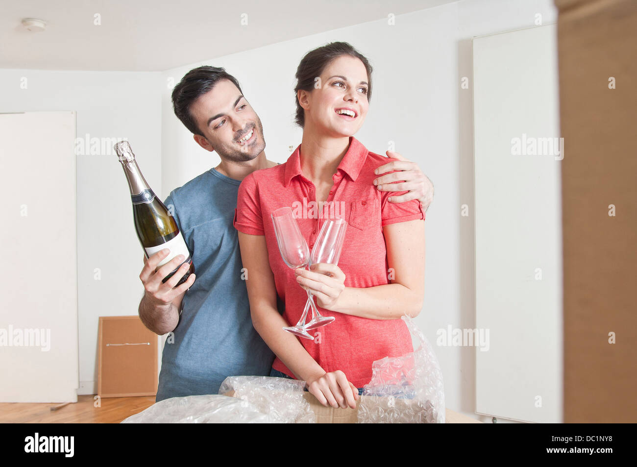Junges Paar feiert Haus bewegen sich mit Champagner Stockfoto