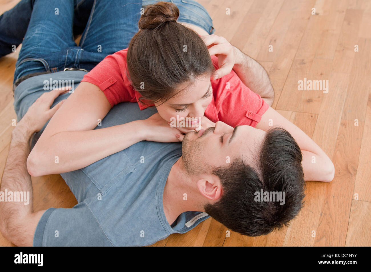 Junges Paar liegen zusammen auf Holzboden Stockfoto