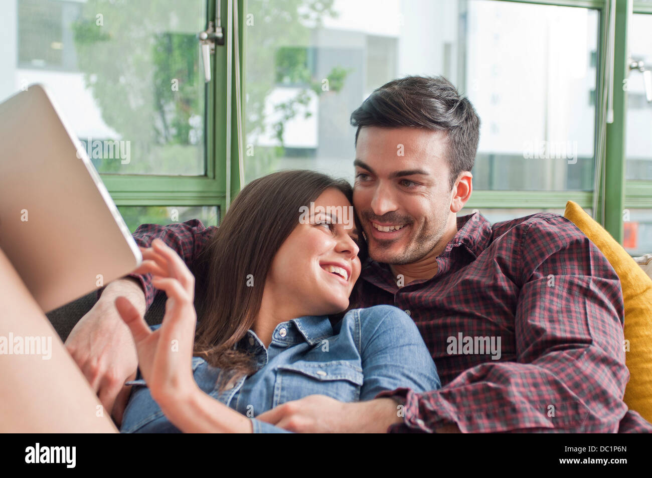 Romantisches Brautpaar auf Sofa mit digital-Tablette Stockfoto