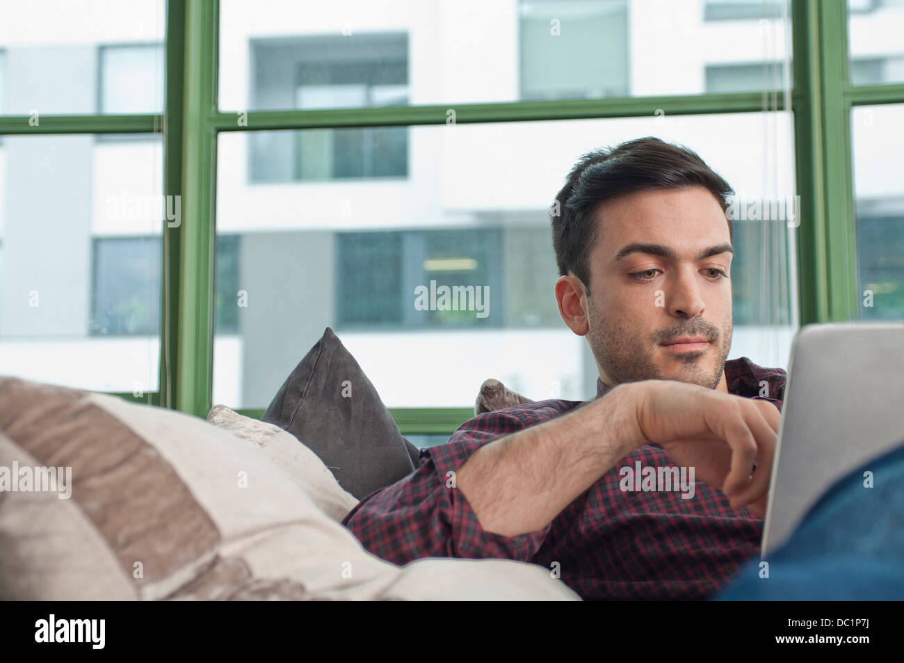 Junger Mann zu Hause mittels digital-Tablette Stockfoto