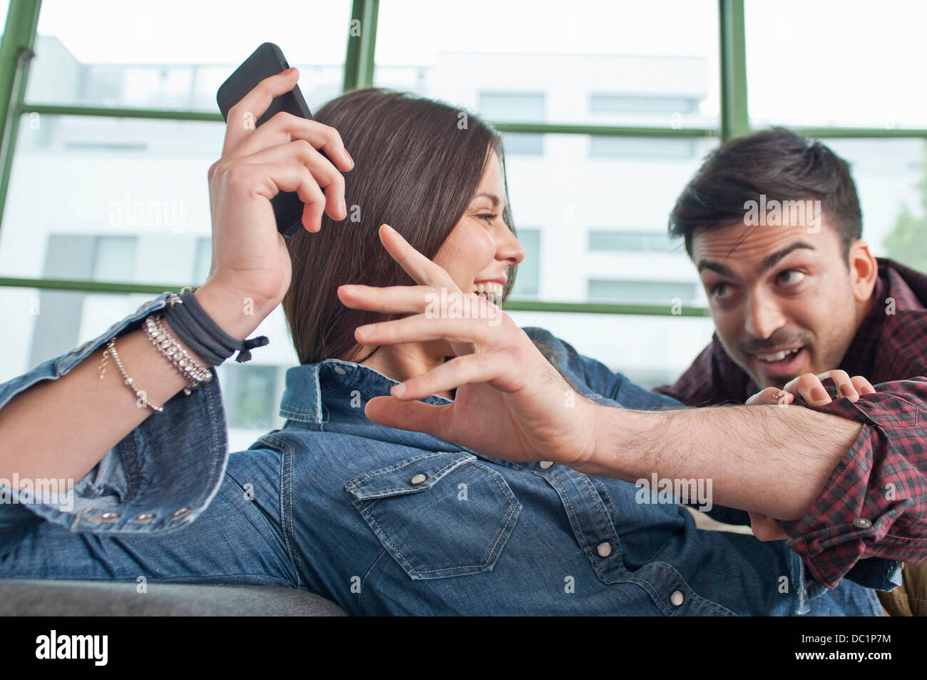 Junges Paar zu Hause täuschen über mit Handy Stockfoto