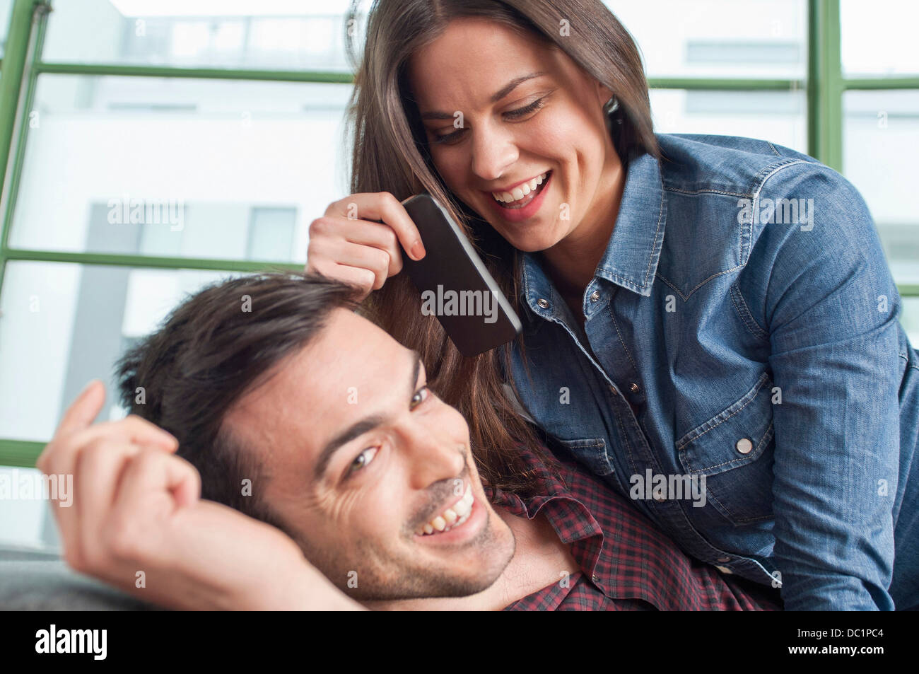 Nahaufnahme eines jungen Paares im Hause Flickschusterei mit Handy Stockfoto